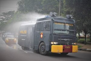 Gunakan Water Canon, Polres Serang Kota Semprotkan Disinfektan ke Jalan