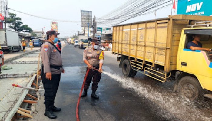 Polsek Pasar Kemis Siram Jalan, Kurangi Dampak Debu Abu Vulkanik